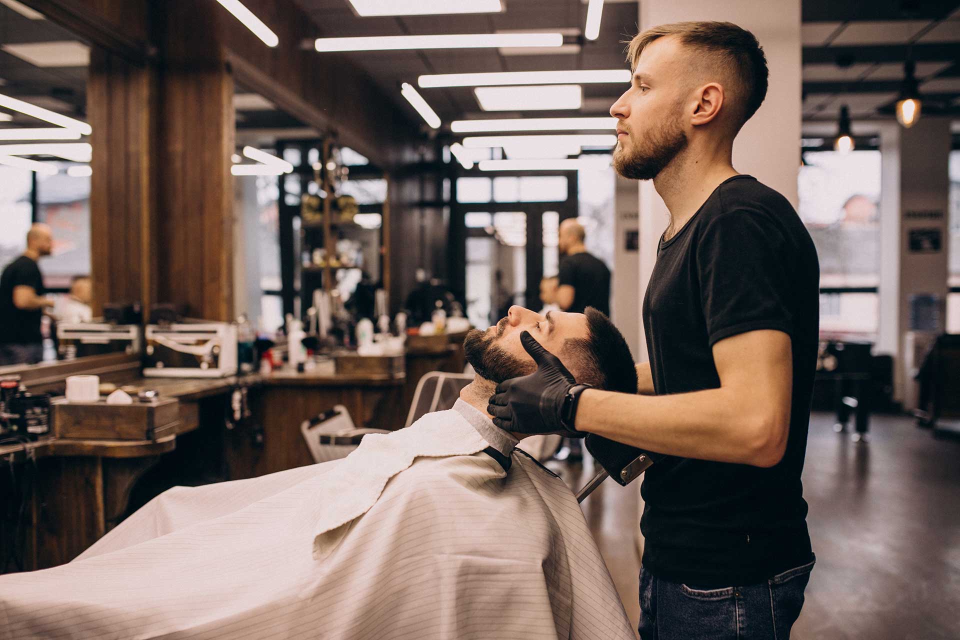 Homem ajeitando a barba em uma barbearia