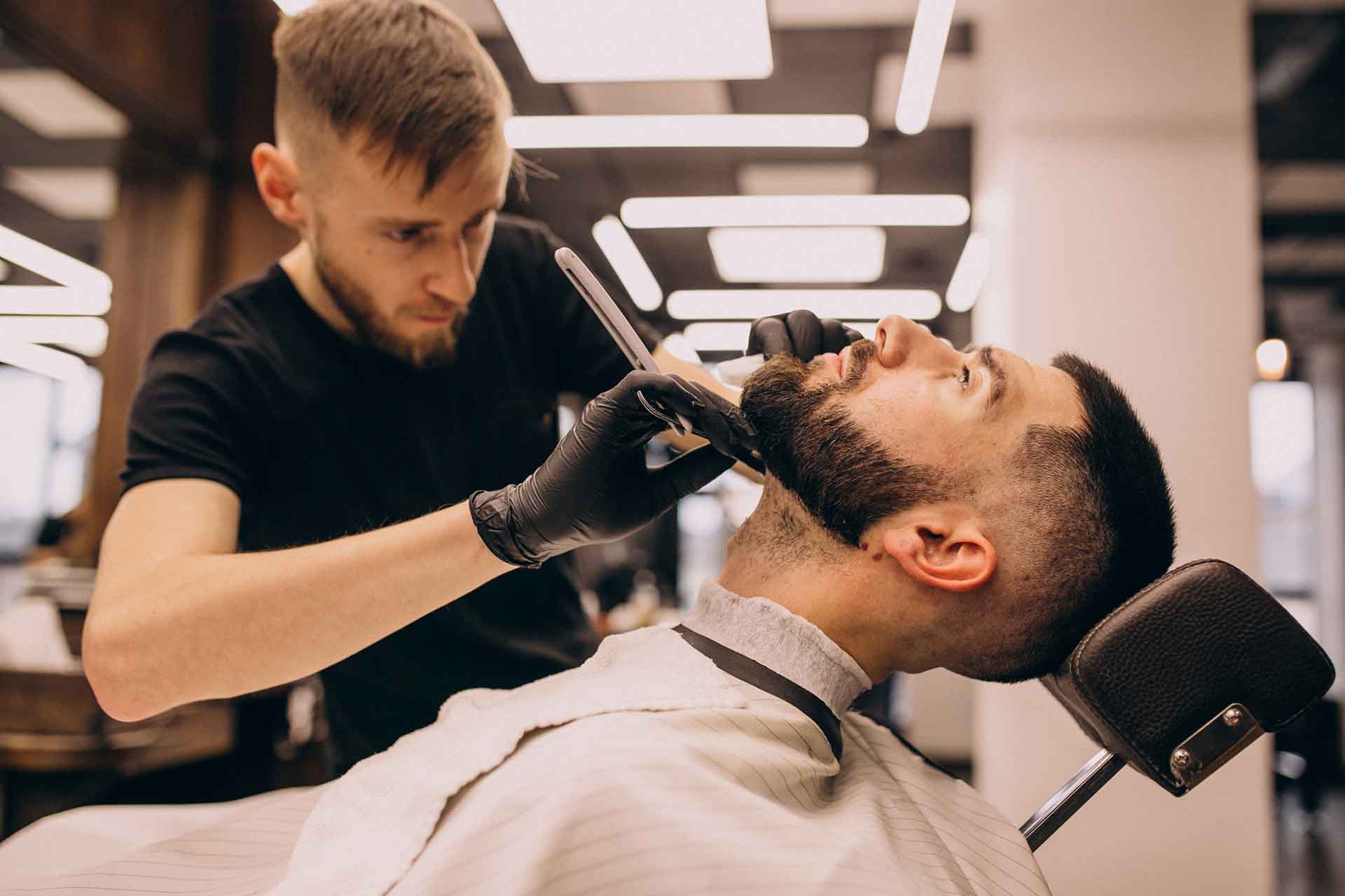 Homem ajeitando a barba em uma barbearia