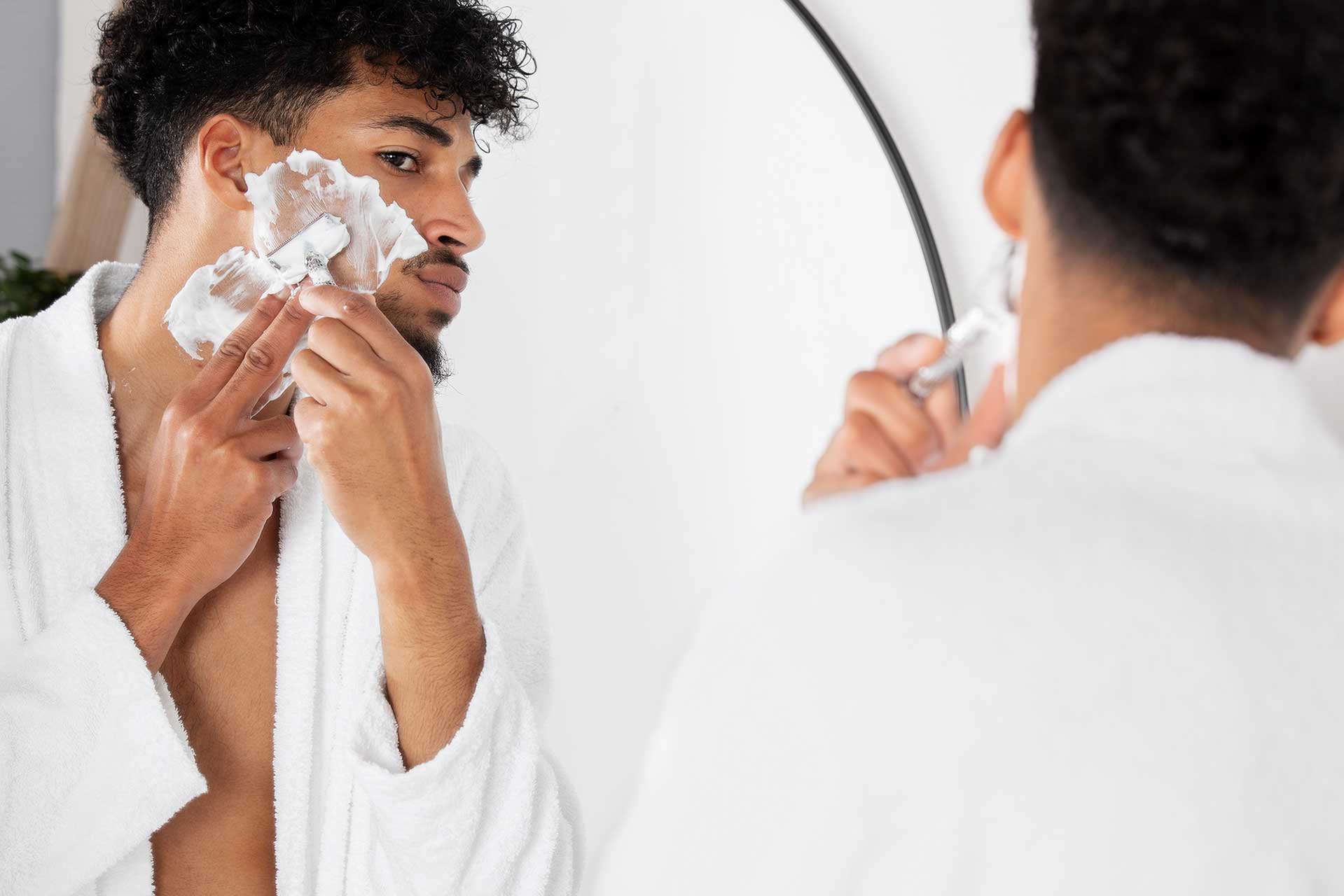 Homem em frente a um espelho, utilizando produtos masculinos