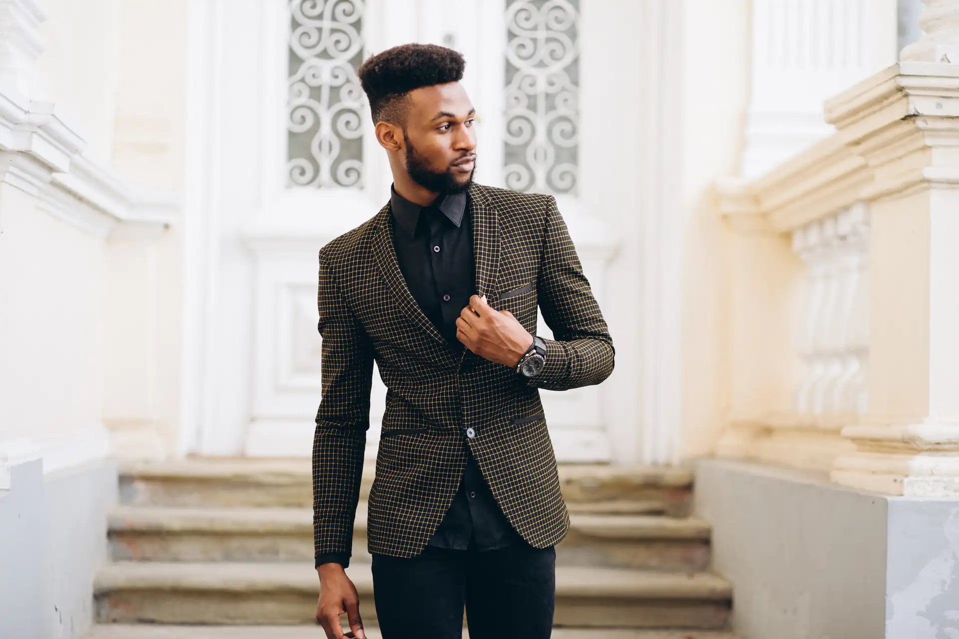 Homem de pele negra utilizando um look masculino esporte fino