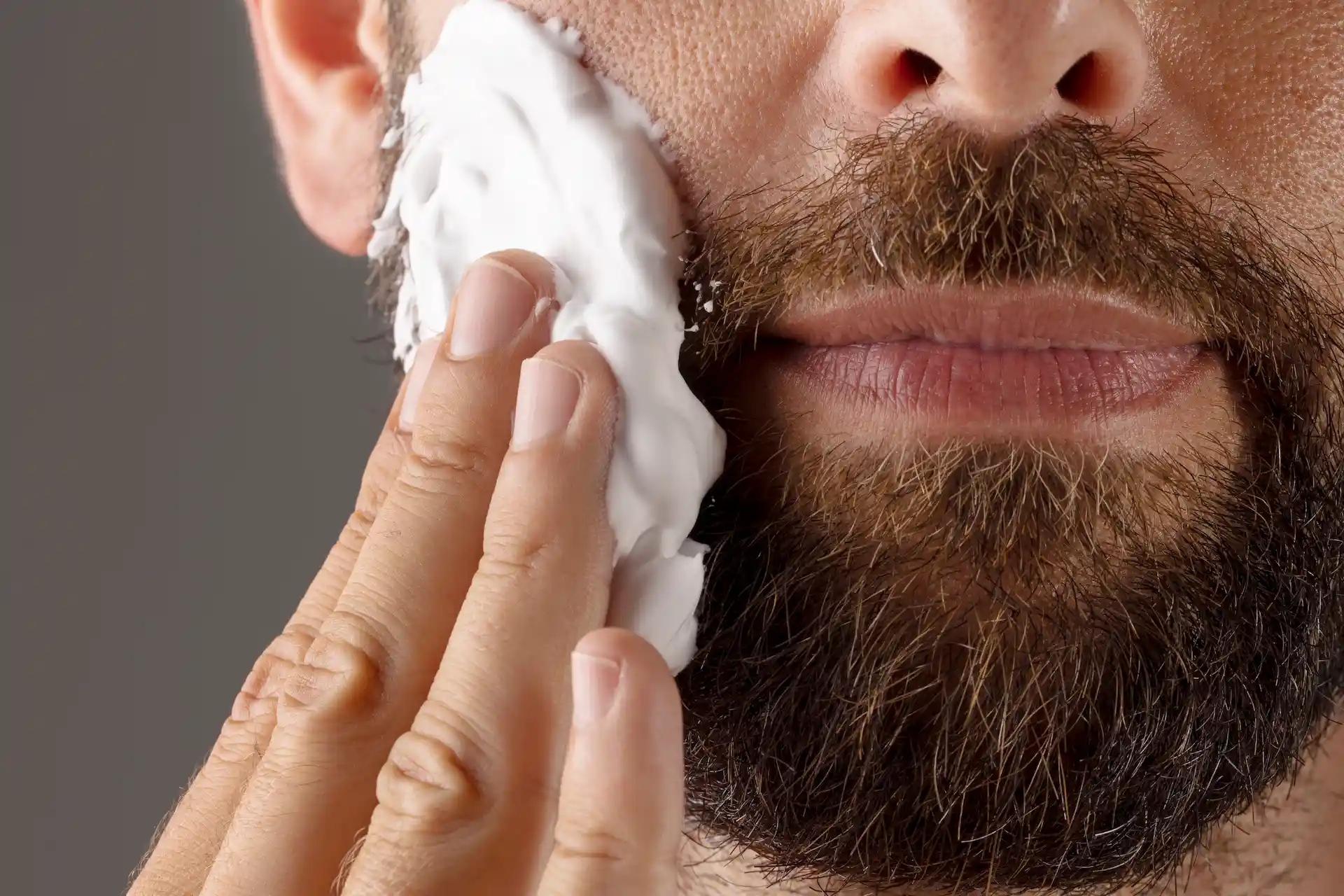 Homem lavando a barba com produto adequando. Um dos passos para evitar uma barba feia