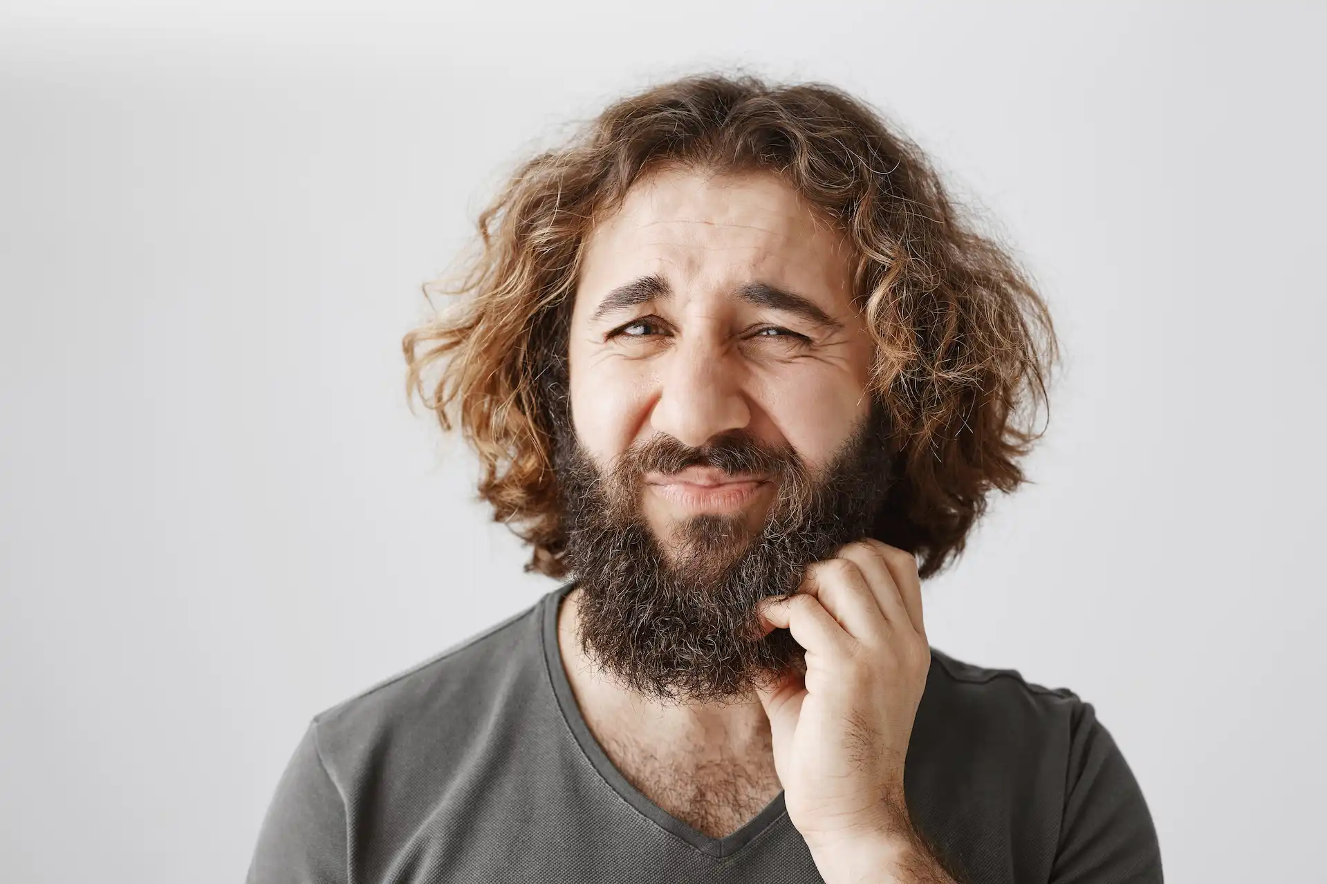 Homem coçando a barba. Como deixar a barba crescer da melhor forma e evitar a coceira, um dos problemas mais comuns