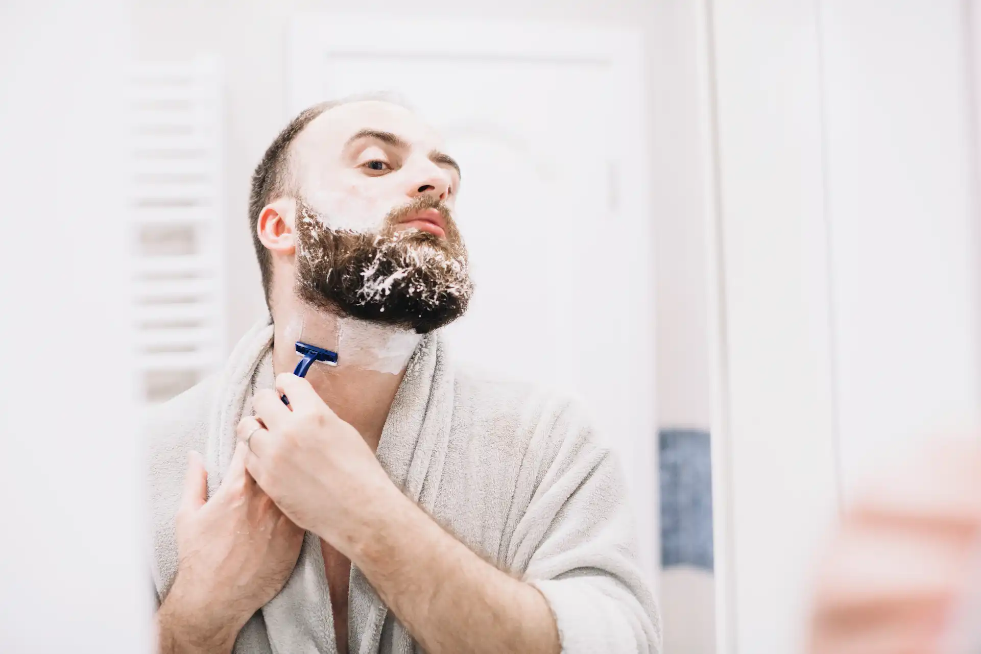 Homem utilizando uma lâmina de barbear. Uma boa lâmina é importante para fazer a barba corretamente e evitar irritação na pele.