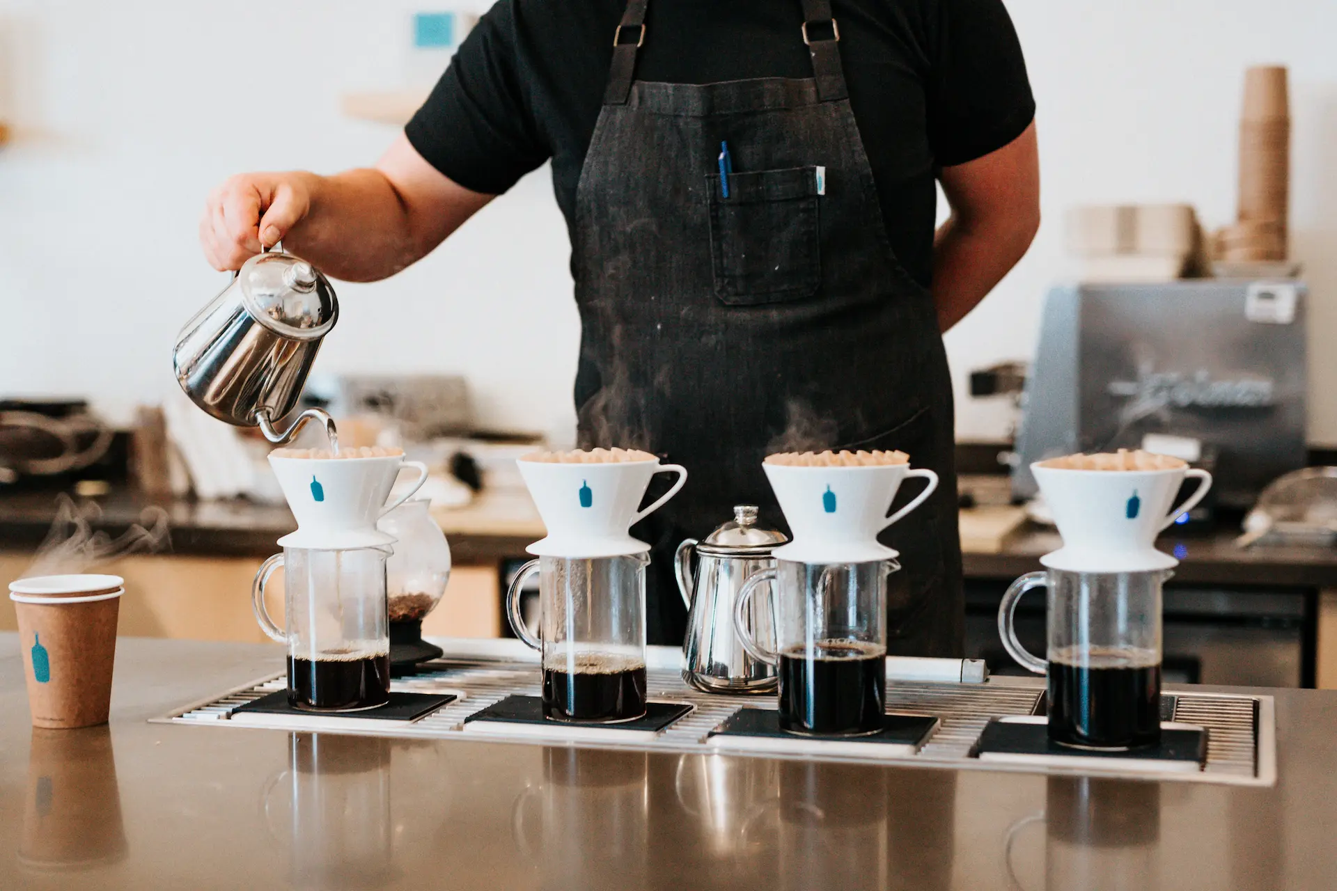 Barista preparando cafés coados.