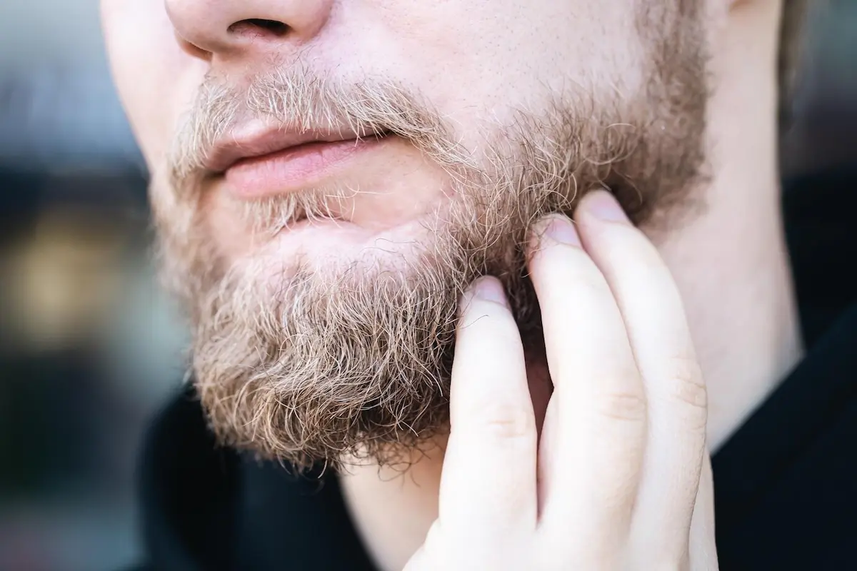 Homem coçando a barba.