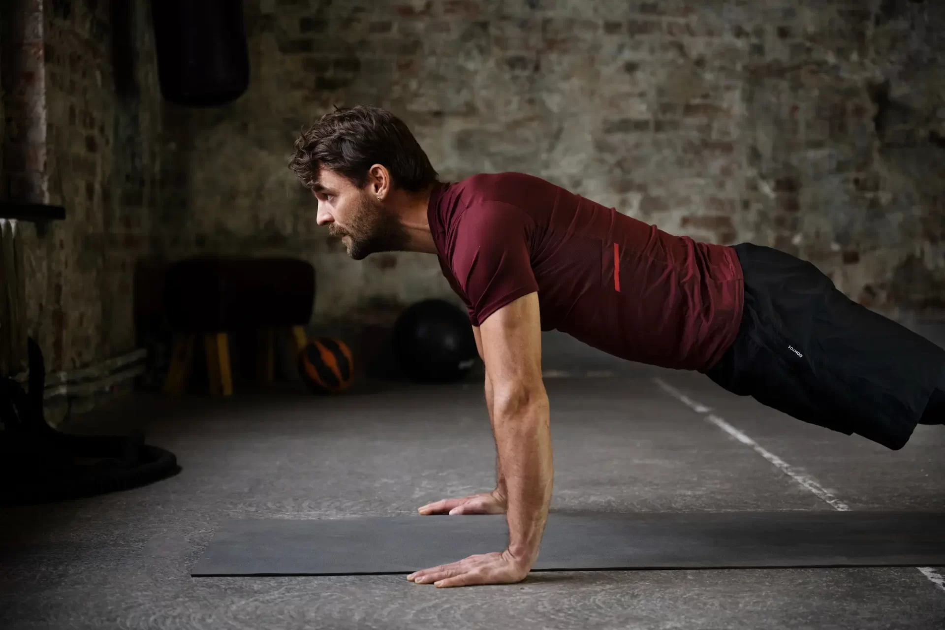 Homem na posição de prancha. Um dos diversos exercícios para fortalecer o core sem o uso de equipamentos.