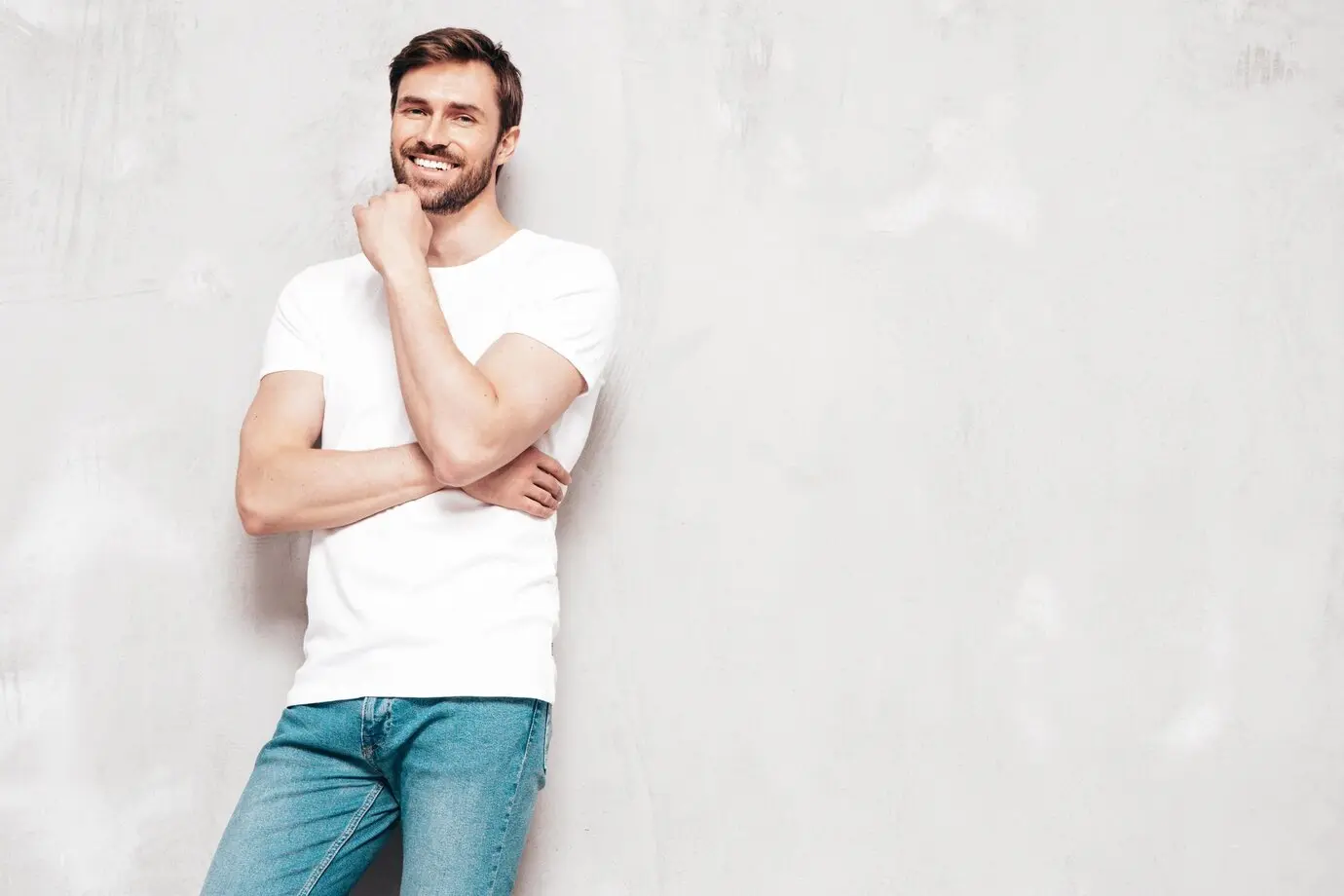 Homem utilizando camiseta básica branca e calça jeans azul.